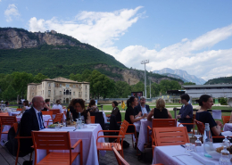 Participants and speakers enjoy lunch together at the MuSe Museum cafe, surrounded by the mountains of Trento, Italy.